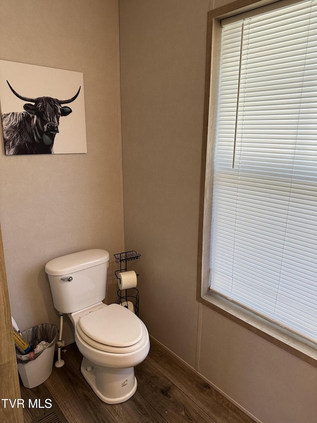 bathroom featuring toilet, baseboards, and wood finished floors