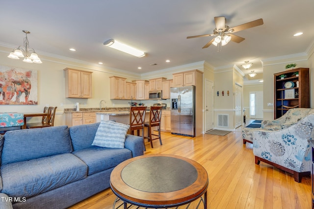 living area with visible vents, ornamental molding, light wood-style flooring, and recessed lighting