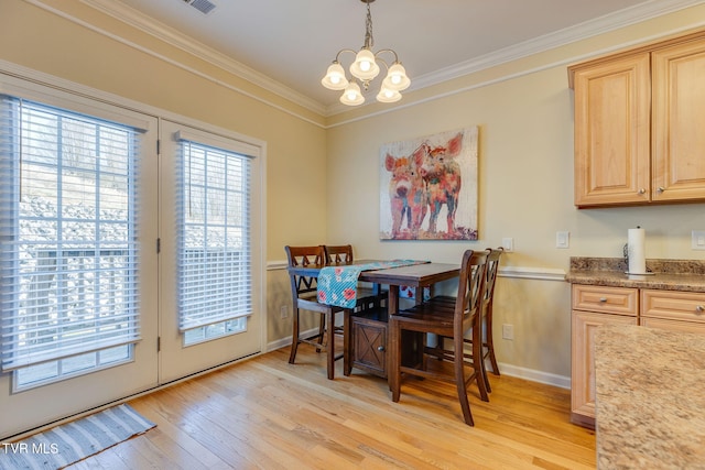 dining area featuring a notable chandelier, light wood finished floors, visible vents, ornamental molding, and baseboards