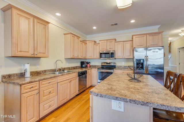 kitchen featuring visible vents, stainless steel appliances, crown molding, light brown cabinetry, and a sink