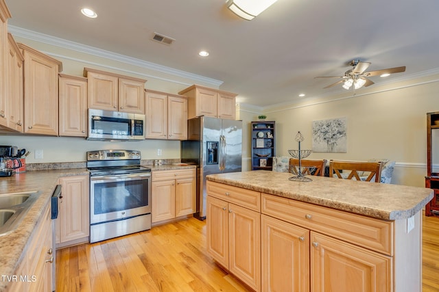 kitchen featuring stainless steel appliances, light wood finished floors, and light brown cabinetry