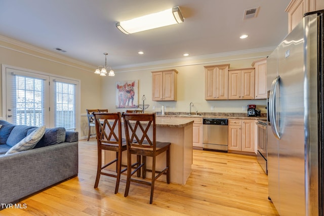 kitchen featuring light brown cabinets, visible vents, stainless steel appliances, and open floor plan