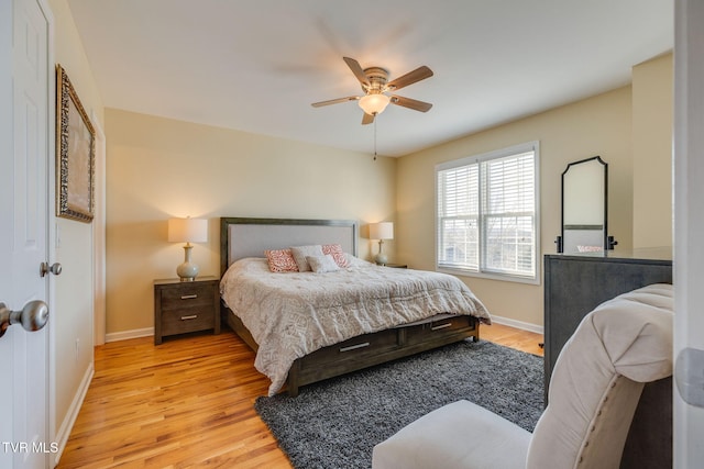 bedroom featuring light wood-type flooring, a ceiling fan, and baseboards