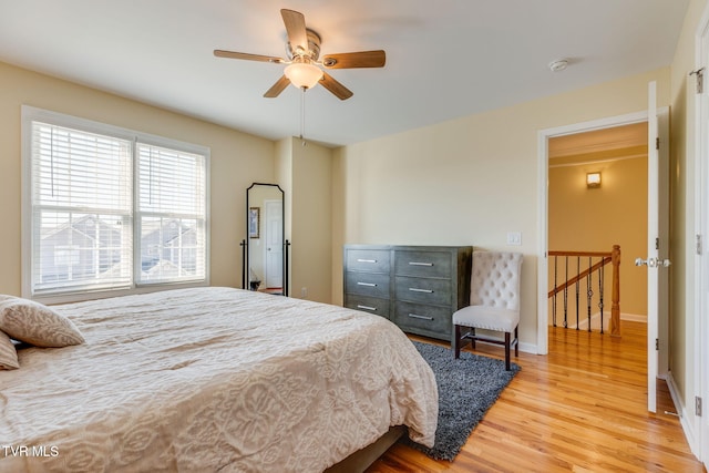 bedroom with wood finished floors, a ceiling fan, and baseboards