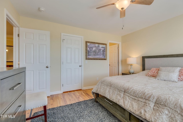 bedroom featuring ceiling fan, baseboards, and wood finished floors