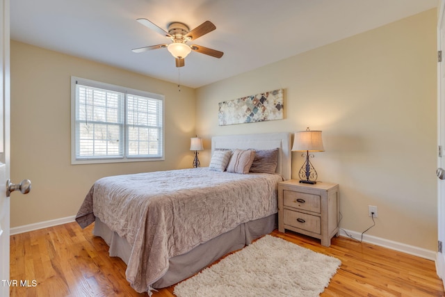 bedroom featuring ceiling fan, light wood finished floors, and baseboards