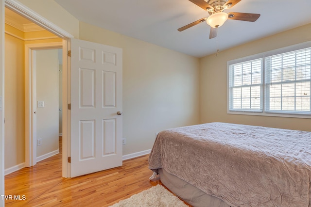 bedroom with a ceiling fan, baseboards, and light wood finished floors