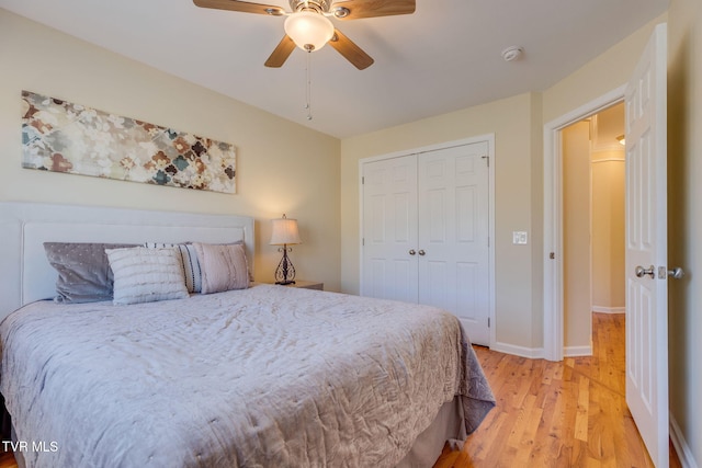 bedroom with baseboards, a closet, a ceiling fan, and light wood-style floors