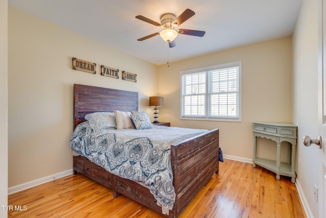 bedroom with ceiling fan, wood finished floors, and baseboards