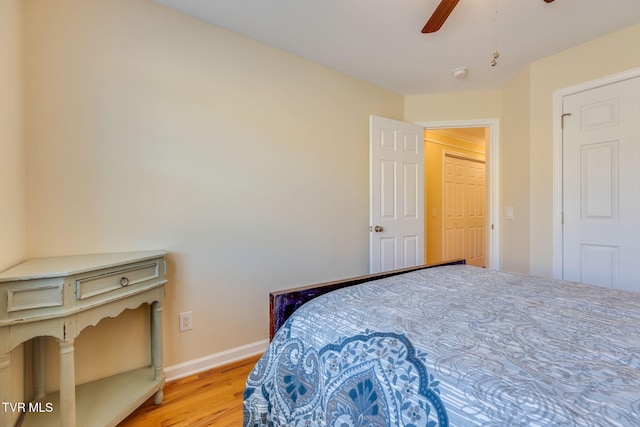 bedroom with a ceiling fan, baseboards, and wood finished floors