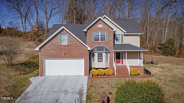 traditional-style house featuring driveway, a porch, a shingled roof, a front lawn, and brick siding