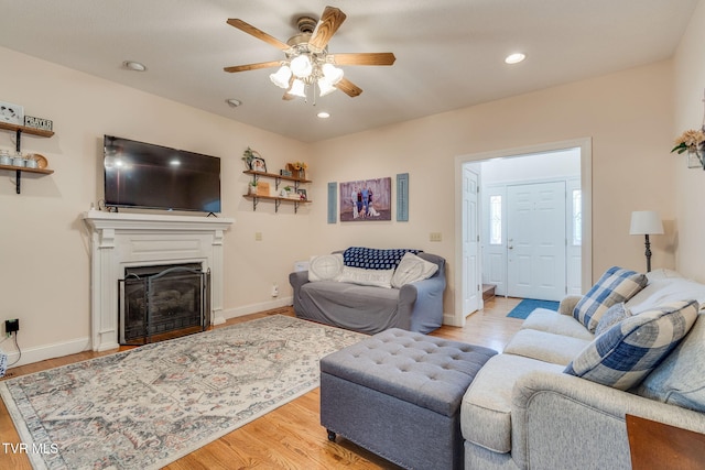 living area featuring wood finished floors, recessed lighting, a fireplace, baseboards, and ceiling fan