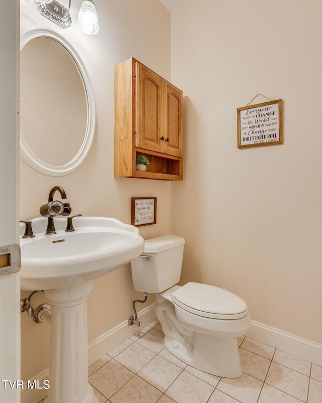 bathroom featuring tile patterned floors, baseboards, and toilet