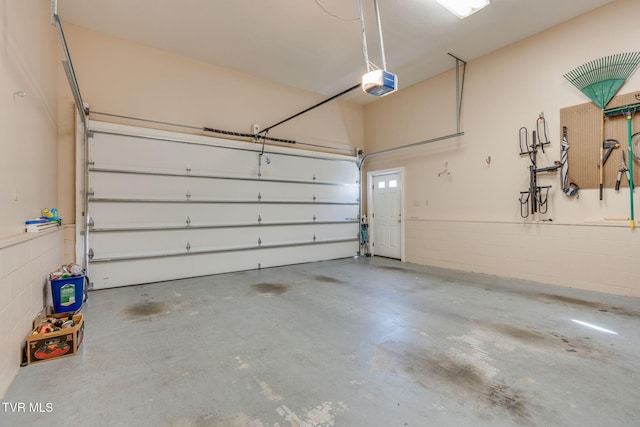 garage with concrete block wall and a garage door opener