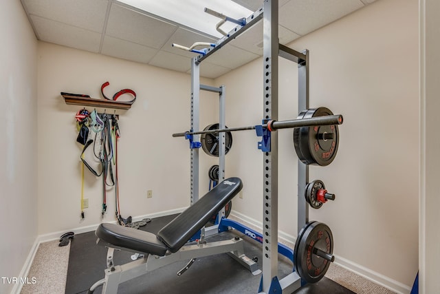 workout area with a drop ceiling and baseboards