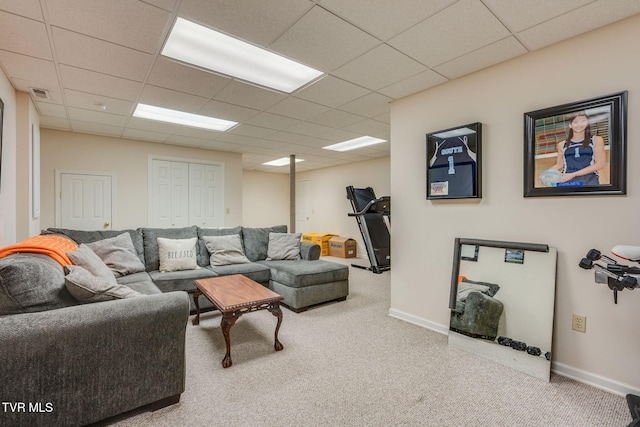 living area featuring carpet flooring, baseboards, visible vents, and a drop ceiling