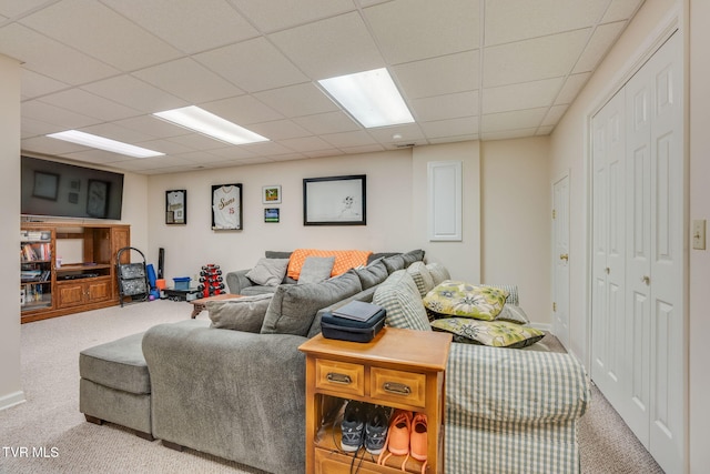 carpeted living area featuring a drop ceiling