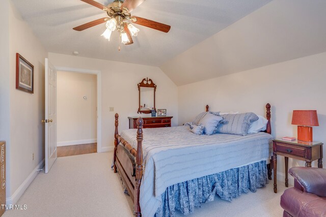 bedroom with light carpet, ceiling fan, baseboards, and lofted ceiling