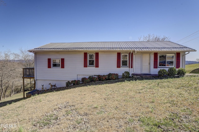 ranch-style house featuring metal roof, a front lawn, and a standing seam roof