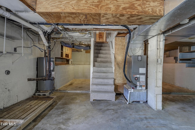 unfinished basement featuring water heater and stairway