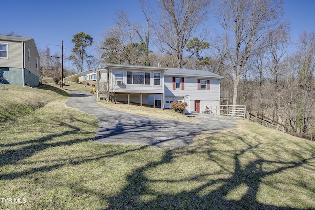 back of house featuring a yard, driveway, and fence