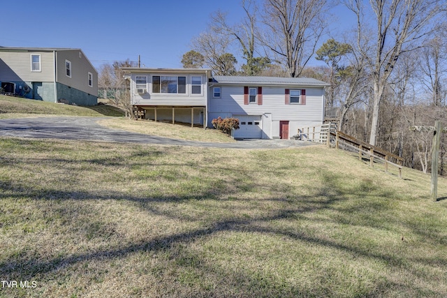 view of front of home with an attached garage, driveway, a front lawn, and stairs