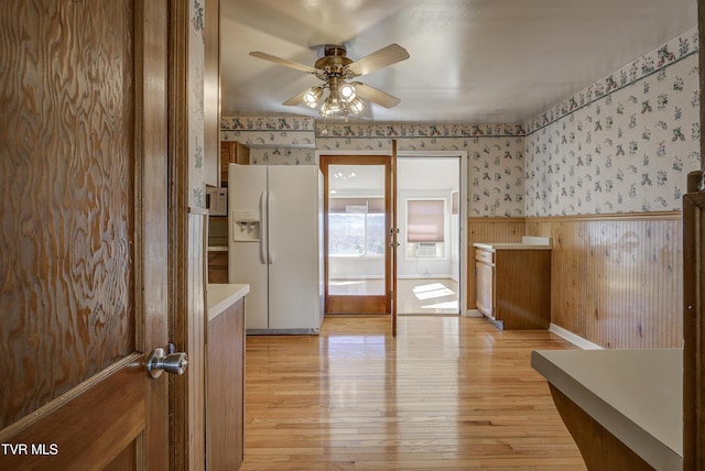 bathroom featuring a wainscoted wall, wood finished floors, a ceiling fan, and wallpapered walls