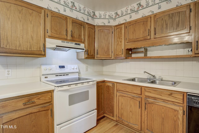 kitchen with under cabinet range hood, white electric range, a sink, black dishwasher, and wallpapered walls