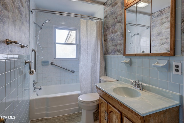 full bathroom featuring tile walls, shower / bathtub combination with curtain, toilet, wainscoting, and vanity