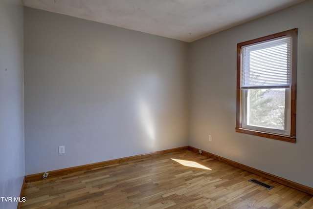 unfurnished room with visible vents, baseboards, and wood finished floors