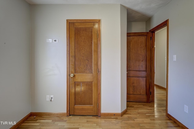 unfurnished bedroom featuring light wood-style flooring and baseboards