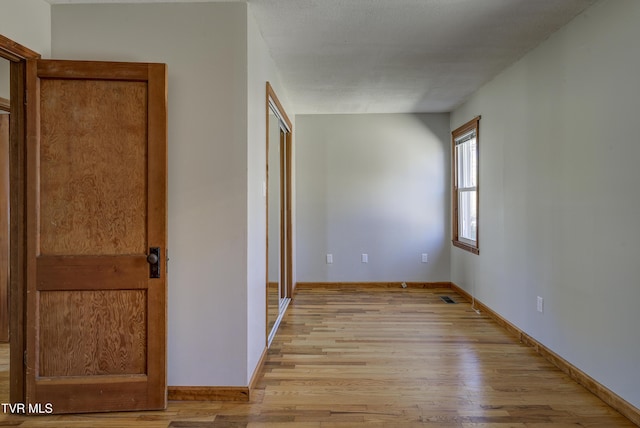 unfurnished bedroom featuring baseboards, visible vents, and light wood-style floors