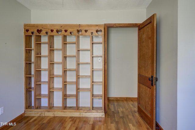 interior space with baseboards and wood finished floors