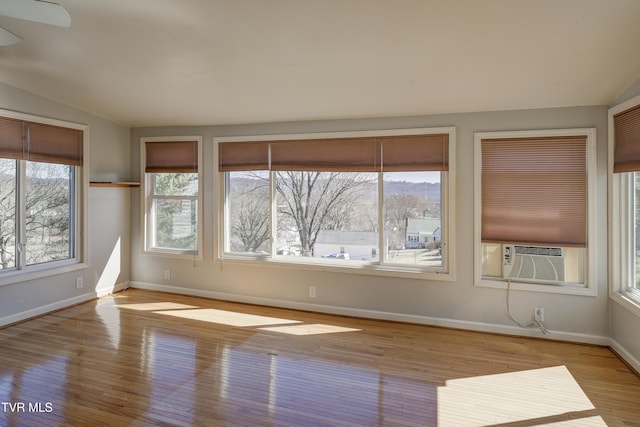 interior space with cooling unit, wood finished floors, and baseboards