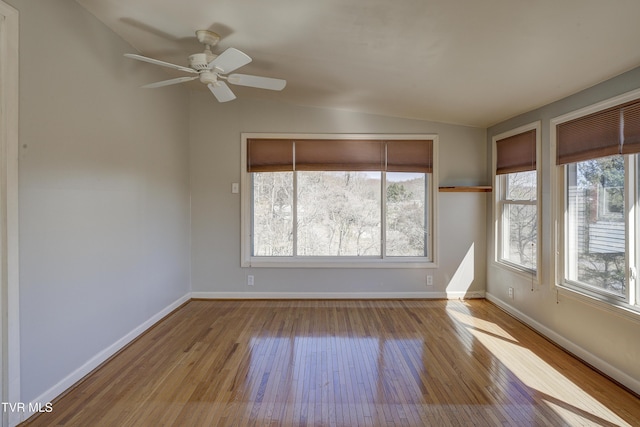 spare room with vaulted ceiling, wood-type flooring, and plenty of natural light