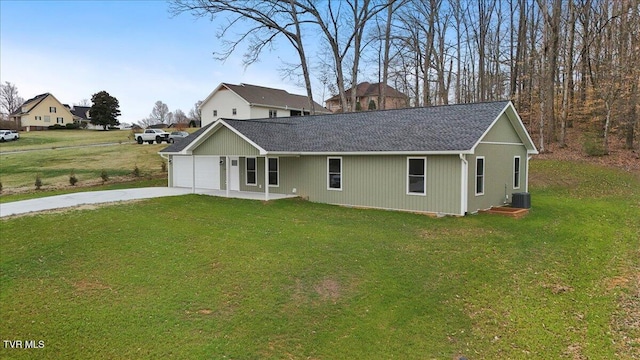 ranch-style house with a garage, driveway, a front lawn, and roof with shingles