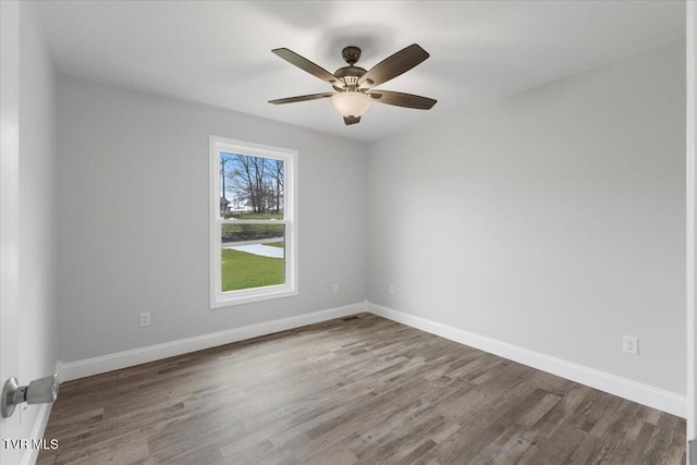 spare room featuring ceiling fan, baseboards, and wood finished floors