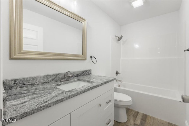 bathroom featuring toilet, bathtub / shower combination, wood finished floors, and vanity