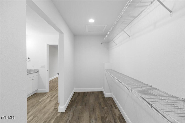 spacious closet with attic access and wood finished floors