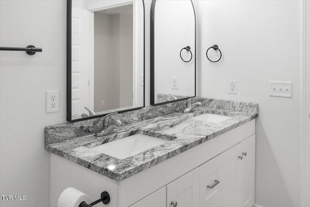 bathroom featuring a sink and double vanity