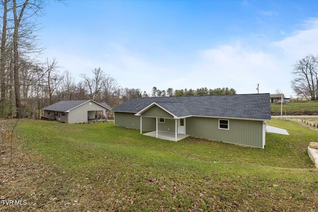 back of house featuring a lawn and a patio