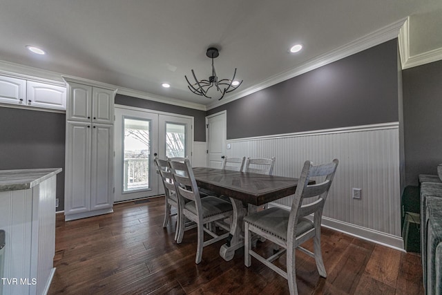 dining room featuring a wainscoted wall, dark wood-style floors, ornamental molding, and french doors