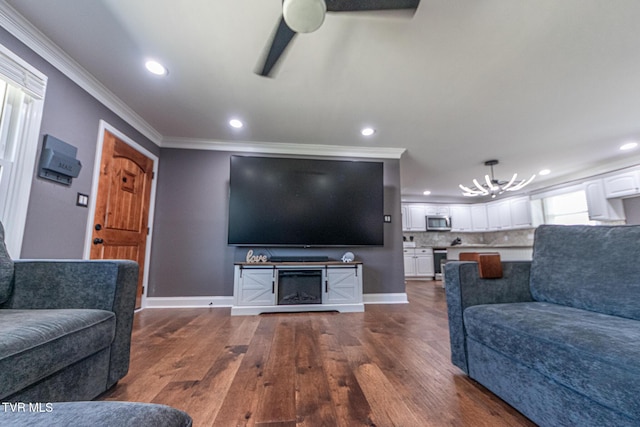 living area with dark wood-style floors, baseboards, a fireplace, and ornamental molding