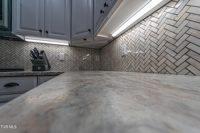 kitchen with decorative backsplash and light stone countertops