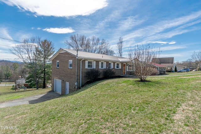 ranch-style home with driveway, a garage, metal roof, a front lawn, and brick siding