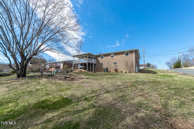 rear view of house featuring brick siding and a lawn