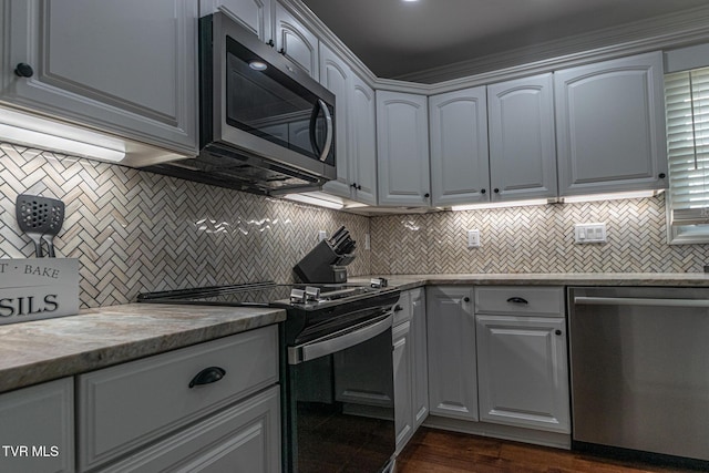 kitchen with dark wood-type flooring, stainless steel appliances, and backsplash