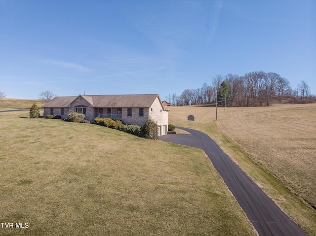 view of front of property featuring driveway and a front lawn