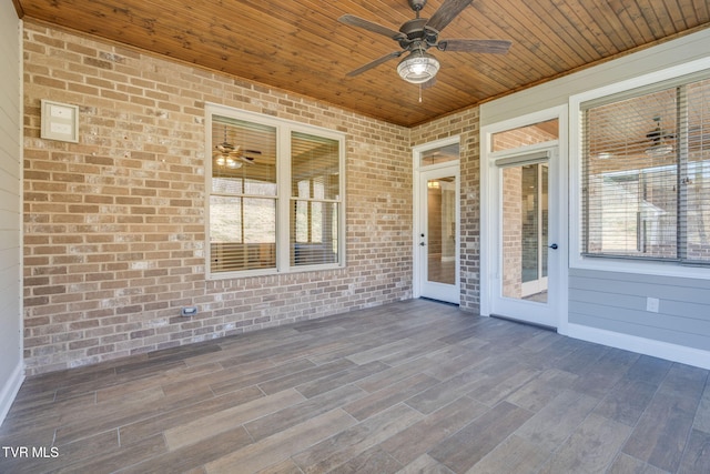 unfurnished sunroom featuring wooden ceiling and ceiling fan