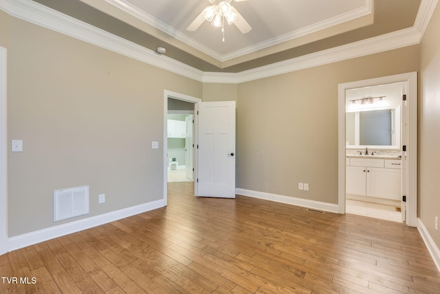 unfurnished bedroom with light wood-style flooring, a sink, visible vents, and baseboards